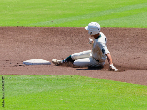 Fototapeta 高校野球の試合で2塁へスライディングするランナー
