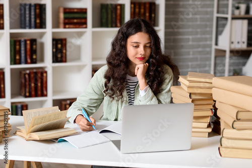 Female student writing in n...