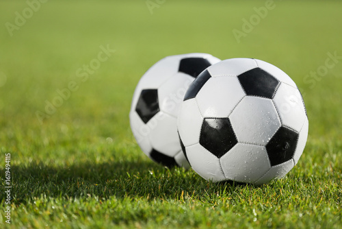 Soccer balls on green stadium grass