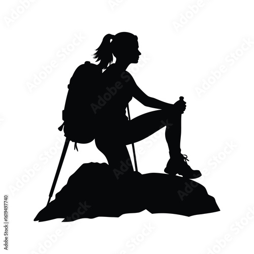 Silhouette of female hiker with trekking poles resting on a rock