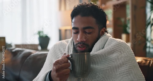 Sick man, blanket and cold with tea on sofa for influenza, virus or flu symptoms in home. Male person, viral infection or shiver with cup, mug or herbal drink for warmth, illness or fever in house