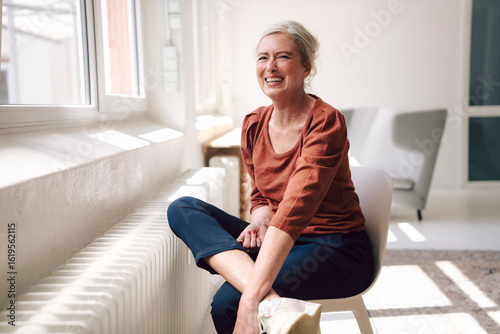 Happy businesswoman in casual clothing smiling in bright modern loft