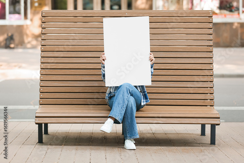 Young woman holding blank p...