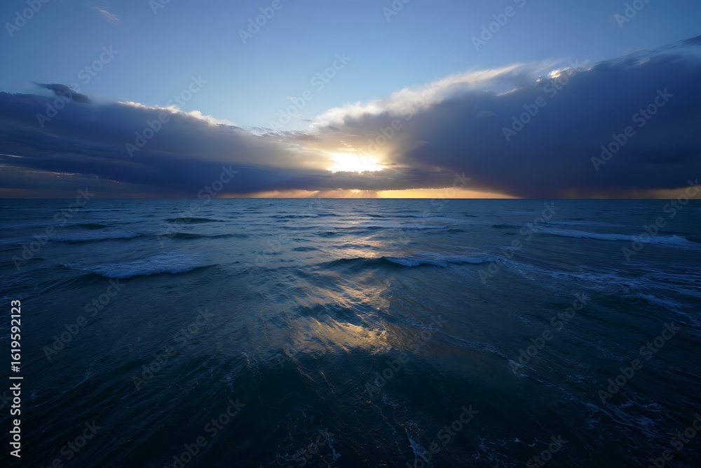 Obraz premium Dramatic sunset over the ocean with clouds and golden light reflection