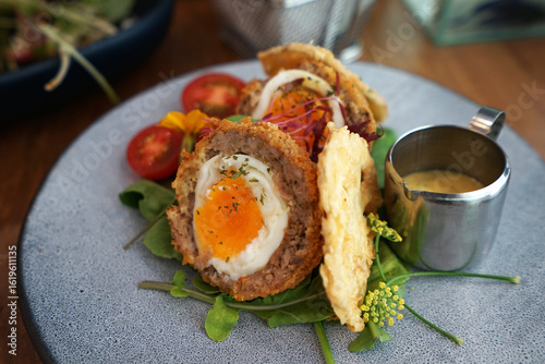 Close up Scotch egg consists of a whole soft or hard-boiled egg wrapped in sausage meat, coated in bread crumbs and baked or deep-fried