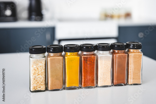 Fototapeta Naklejka Na Ścianę i Meble -  organised tidy spice jars on kitchen countertop featuring pantry staples and different flavours for home cooking