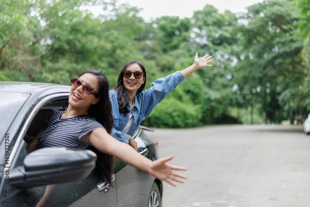 Obraz premium Happy tourists waving from car window during road trip