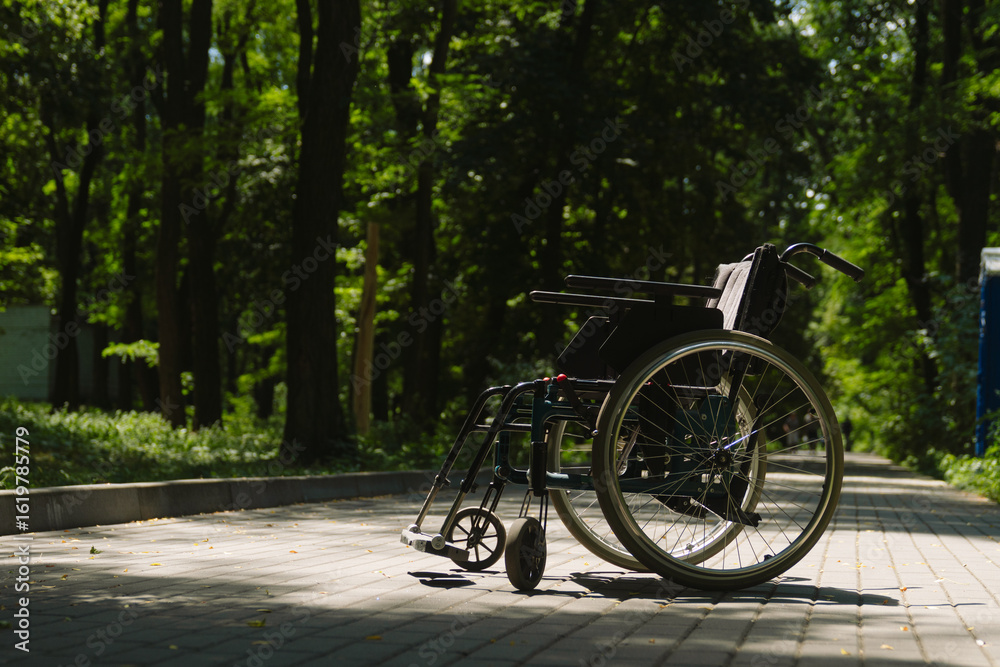 Fototapeta premium Empty Wheelchair in Peaceful Park on Sunny Day