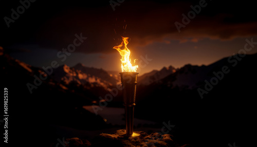 Winter Olympics torch at the top of Italian mountains in dark evening light. Orange fire and last light in mountain landscape Winter Games in Milan and Cortina 2026