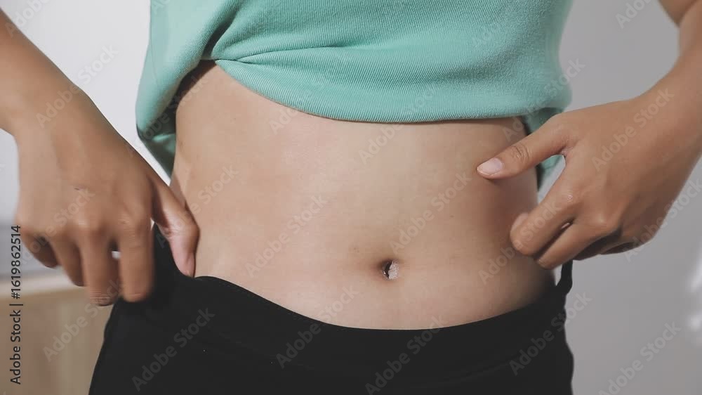 woman's hand holding excessive belly fat, overweight concept woman's hand holding excessive belly fat, overweight concept