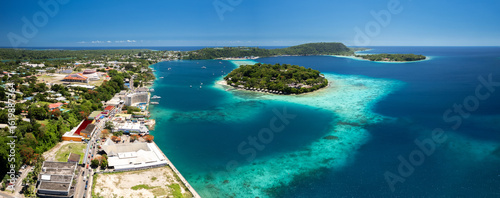 Aerial view of Iririki Island in Port Vila Harbour, Vanuatu, surrounded by turquoise lagoon, coral reefs, and tropical greenery in the South Pacific.