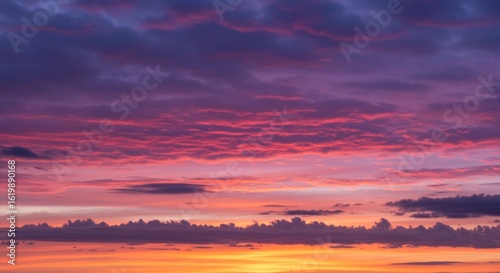 Vibrant sunset sky ablaze with pink, orange, purple, and gray altocumulus clouds in a picturesque display