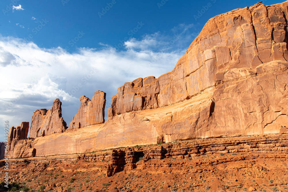 Fototapeta premium High walls of geological sandstone formation called Park Avenue in Arches National Park, Utah, USA with deep colors during last hours of sunshine of the day
