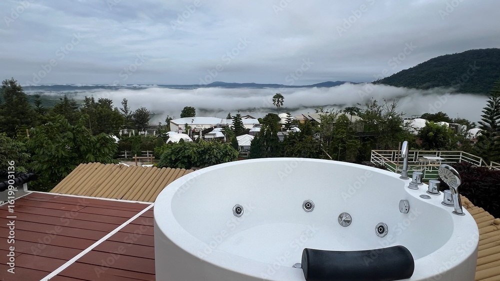 Obraz premium Phetchabun, Thailand, Outdoor jacuzzi with mountain view surrounded by fog, trees and white dome tents at Stratus Resort, Khao Kho.