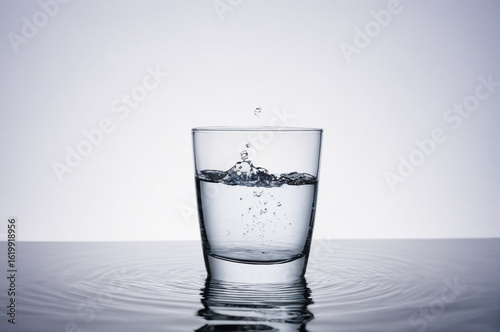 Water Droplet Splashing into a Glass of Water. Generative AI. 