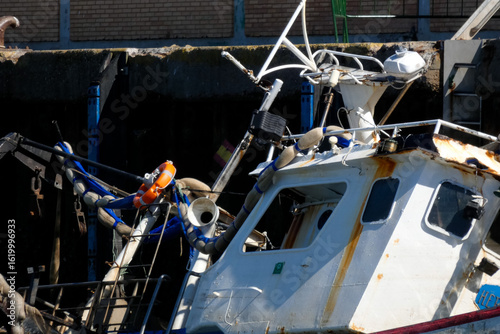 Sunken fishing boat partially submerged in harbor, maritime accident scene