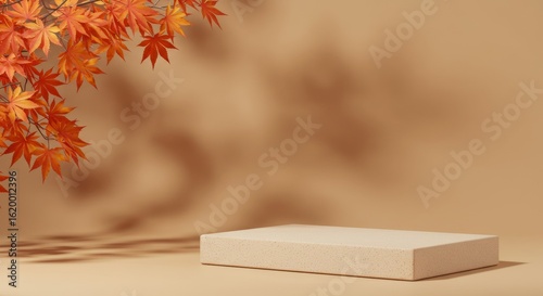 Beige podium with red autumn leaves and shadows on tan wall.