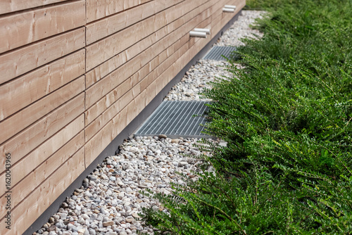 Foundation French Drain Drainage Systems. Drain Stone Layer or Crushed Stone with Drainage Grate Outdoor Facade Exterior Building. 