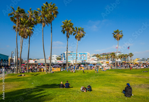 View of palm trees and visitors on Ocean Front Walk in Venice Beach, Los Angeles, California