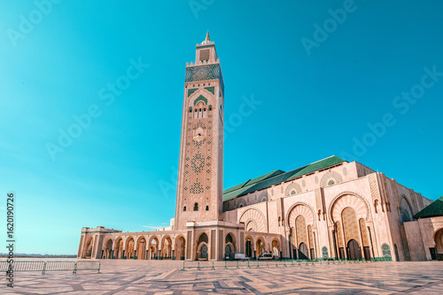 Wall Mural Hassan II Mosque with its minaret towering over the paved square under the vibra