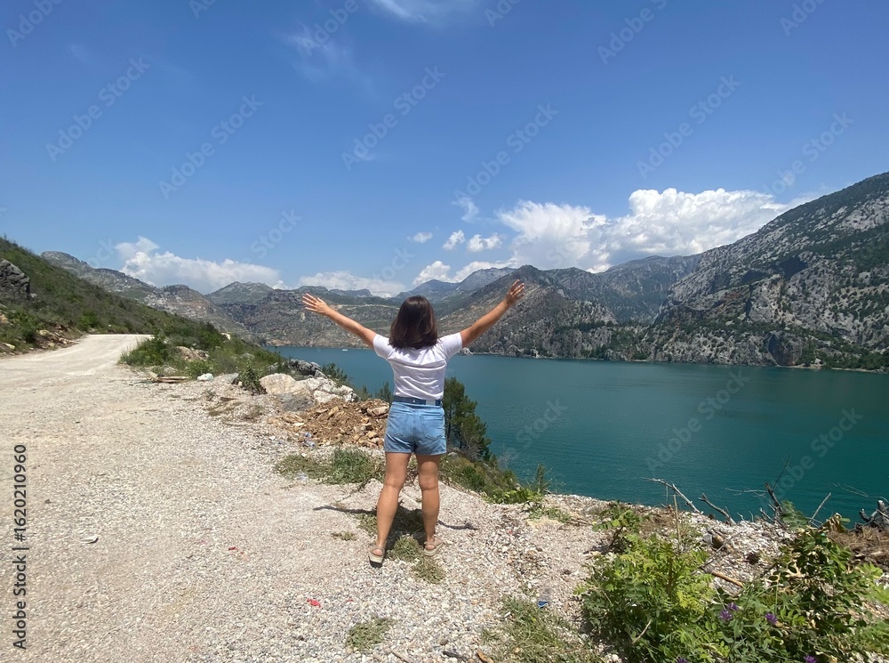 Naklejka premium Scenic view of Green Canyon in Turkey with turquoise lake and mountain range in background. Summer travel destination with clear sky and natural landscape.