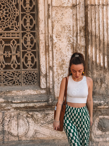 Woman standing near carved Islamic wall at the Citadel