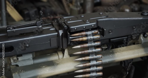 Close-up detail of a historic German MG 42 general-purpose machine gun. An ammunition belt with cartridges is fed into the receiver of the World War II era automatic weapon.