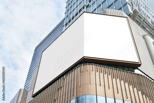 Mock up white corner LED display billboard on shopping mall building. Clipping path for mockup