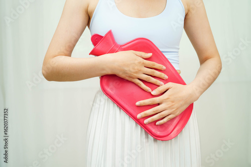 Wallpaper Mural Woman using hot water bottle to relieve menstrual abdominal pain. Torontodigital.ca
