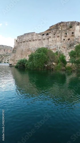 Tourist tour on the Euphrates River with scenic view of Rumkale fortress and surrounding mountains in southeastern Turkey. Historical ruins and scenic nature landscape filmed from moving boat