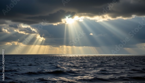 Powerful sun rays breaking through clouds over tranquil ocean waves scenic nature landscape dramatic atmosphere coastal view
