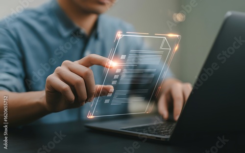 Person interacting with digital document checklist on transparent screen next to laptop management online