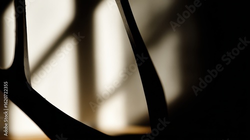 Modern chair leg casting shadows in sunlight, abstract interior design