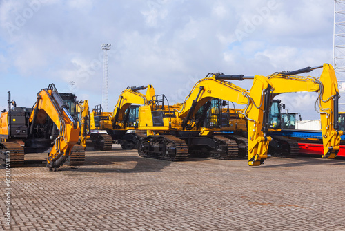 New yellow crawler excavators are parked on the site.