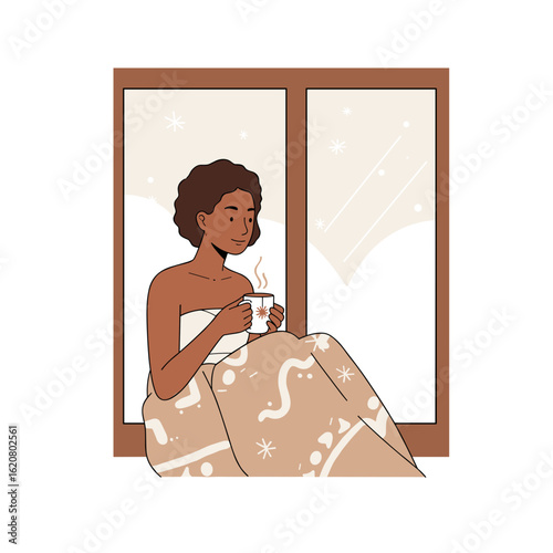 Young Black woman enjoying a warm drink wrapped in a blanket by the window  