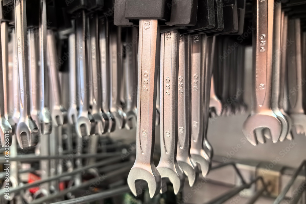 Fototapeta premium Hanging assortment of steel wrenches in a well-organized workshop