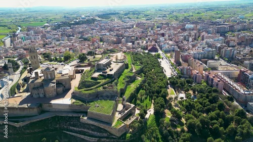 Aerial view of the Gardeny Castle, a Templar fortress, surrounded by green trees and buildings in the urban landscape, Lleida, Spain.