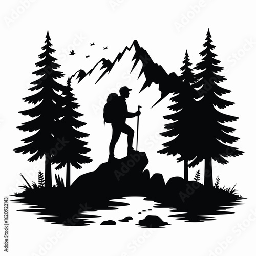 Silhouette of a hiker standing atop a rock overlooking a mountainous landscape.
