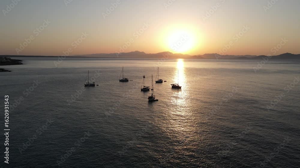 Sunset over coastal waters with anchored boats, aerial drone 4K view, golden horizon reflections, serene maritime beauty and tranquil evening atmosphere Sunset over coastal waters with anchored boats, aerial drone 4K view, golden horizon reflections, serene maritime beauty and tranquil evening atmosphere