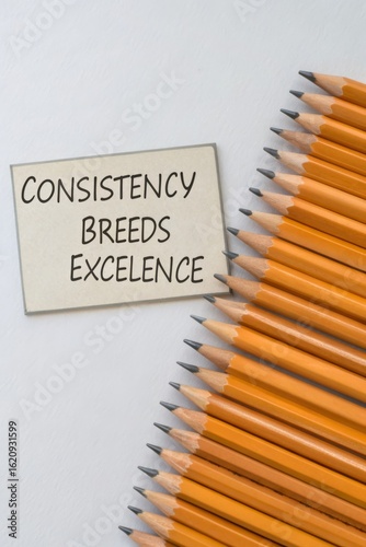 Consistency Breeds Excellence Message on Card with Yellow Pencils