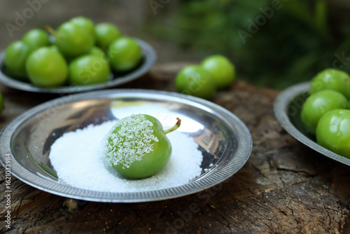 Green Plum with Salt on Metal Plate