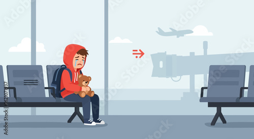 Sad boy with teddy bear in airport waiting area after missing the flight alone