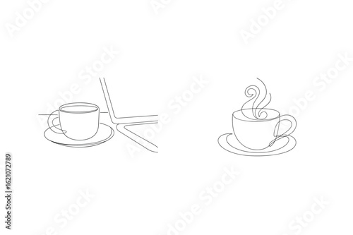 Steaming coffee cup beside laptop saucer