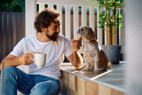 Canvas Print Happy man enjoying with his dog on porch.