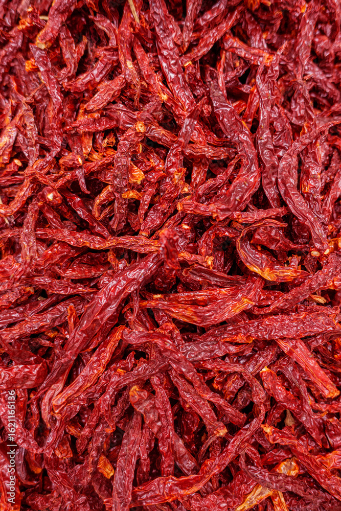 Fototapeta premium Dried red chili peppers piled together showcasing vibrant colors and rich textures for culinary use
