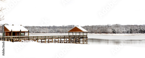Snow scene of a dock on a small lake with ice during winter