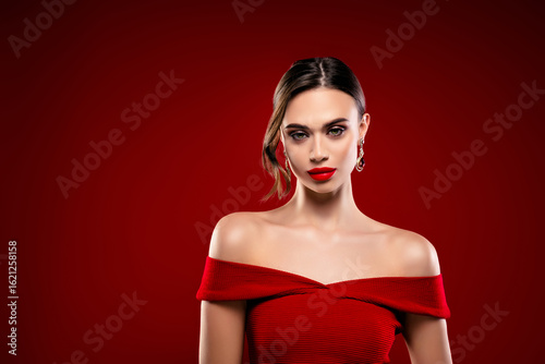 Portrait of young elegant woman in red on vibrant background showcasing beauty, fashion, and style