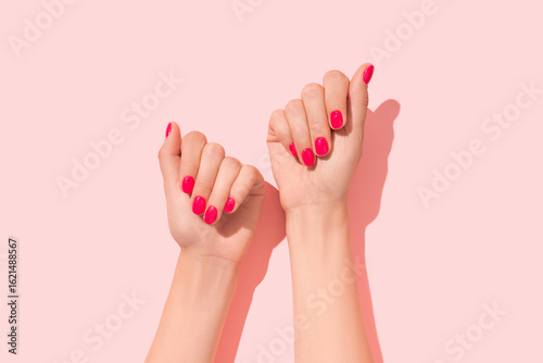 Womans hands with pink nail design. Manicure, pedicure beauty salon concept. Deep long shadows