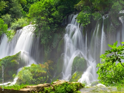 Waterfall flowing through green forest park in Thailand nature scene