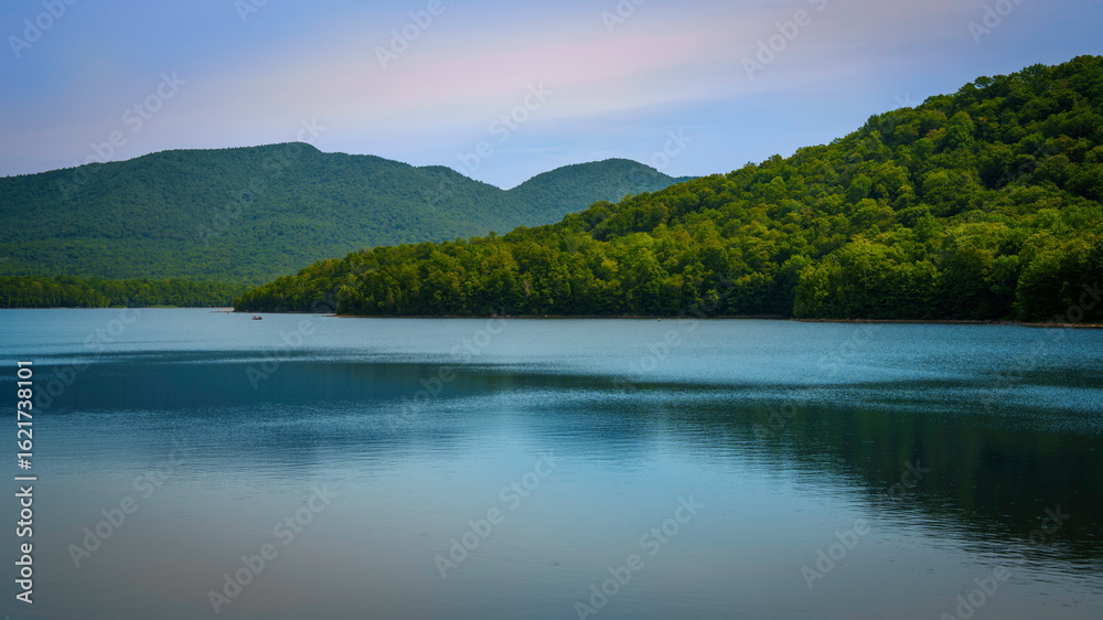 Fototapeta premium Chittenden Reservoir, a 750-acre lake in Vermont’s Green Mountains—tranquil New England summer landscape with forest reflections in still waters.